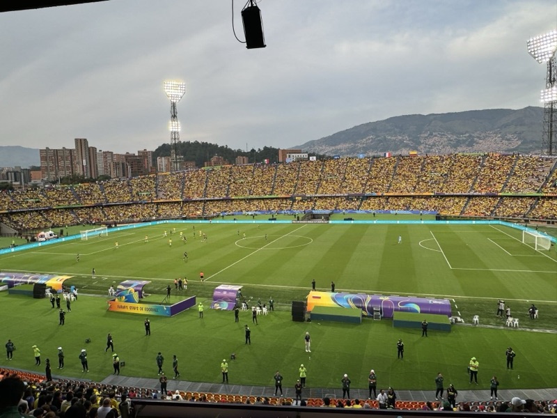 The pitch and stands of Estadio Atanasio Girardot in Laureles-Estadio, with hillside neighborhoods behind