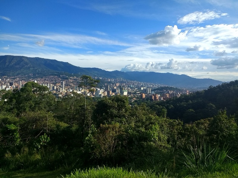 Medellín spread across its green valley, seen from the forested slopes of Cerro El Volador